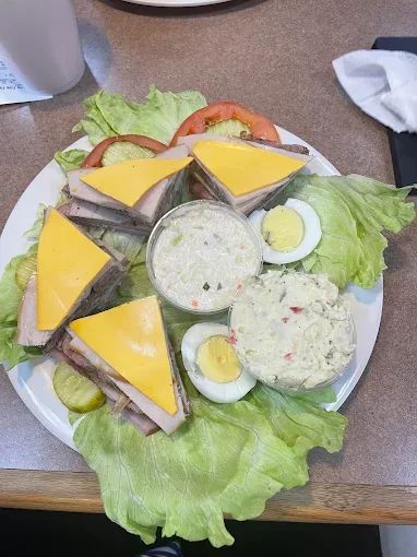 Turkey club sandwich platter with coleslaw, potato salad, and boiled eggs