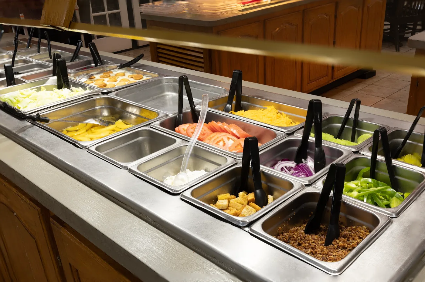 Fresh garden salad bar with sliced tomatoes, cheese, cucumbers, and toppings